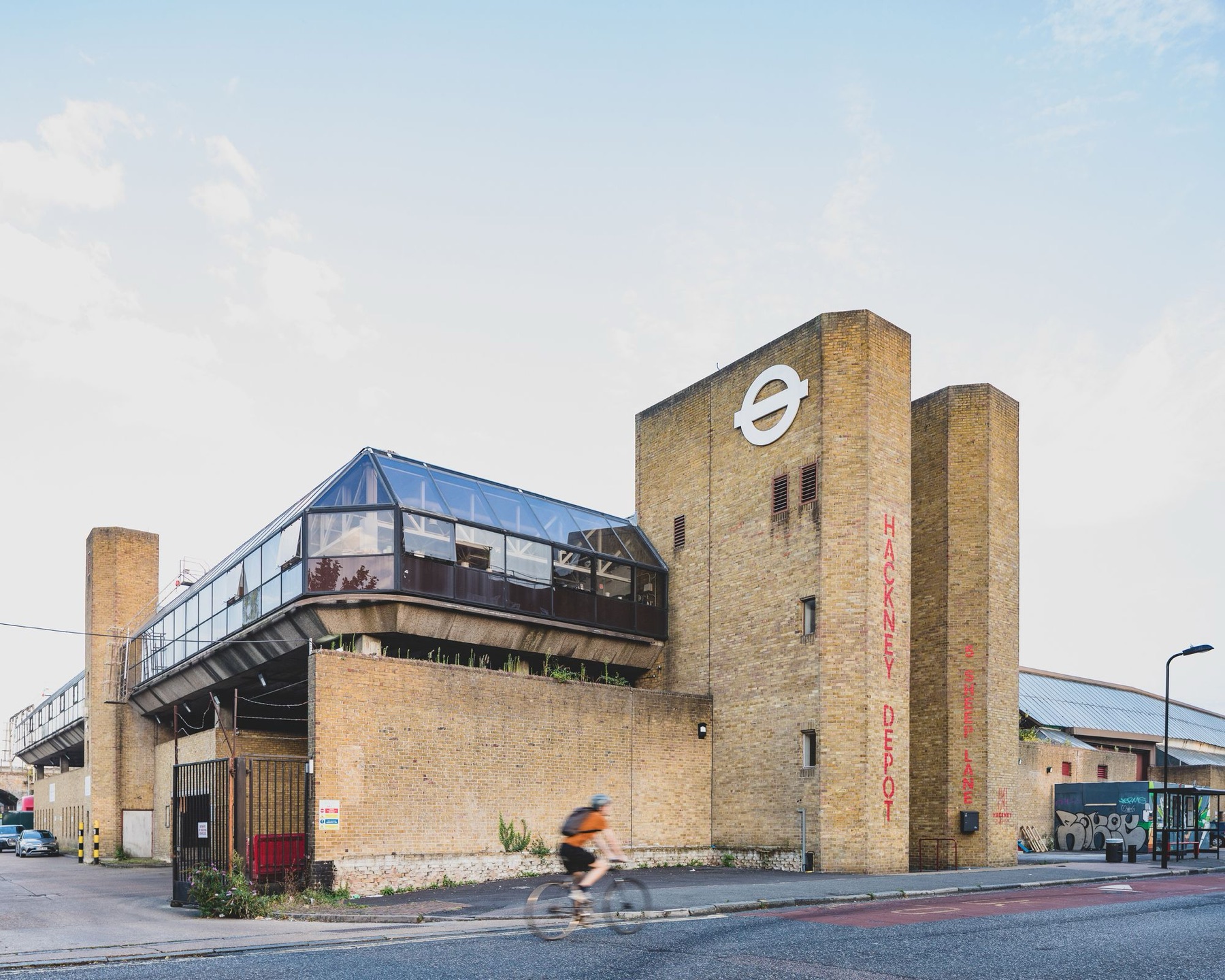Hackney Depot exterior on Sheep Lane, the glass structure above the brick bus depot