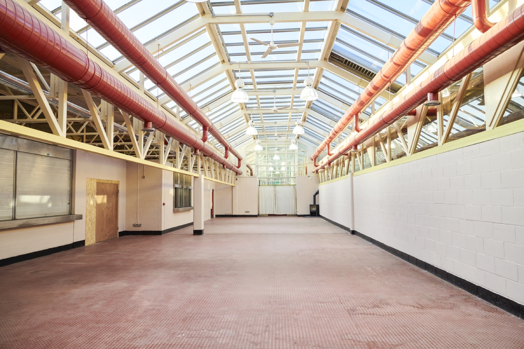 The Main Hall: an open-plan space under a full glazed roof with red ductwork and cream trusses